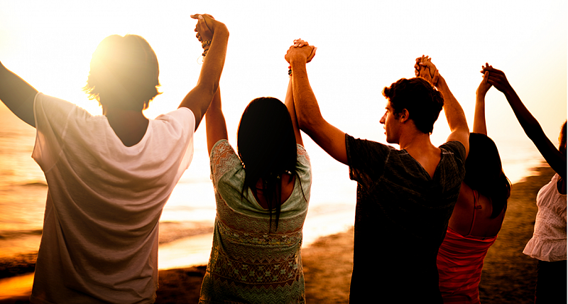 Group of young people celebrating with arms raised